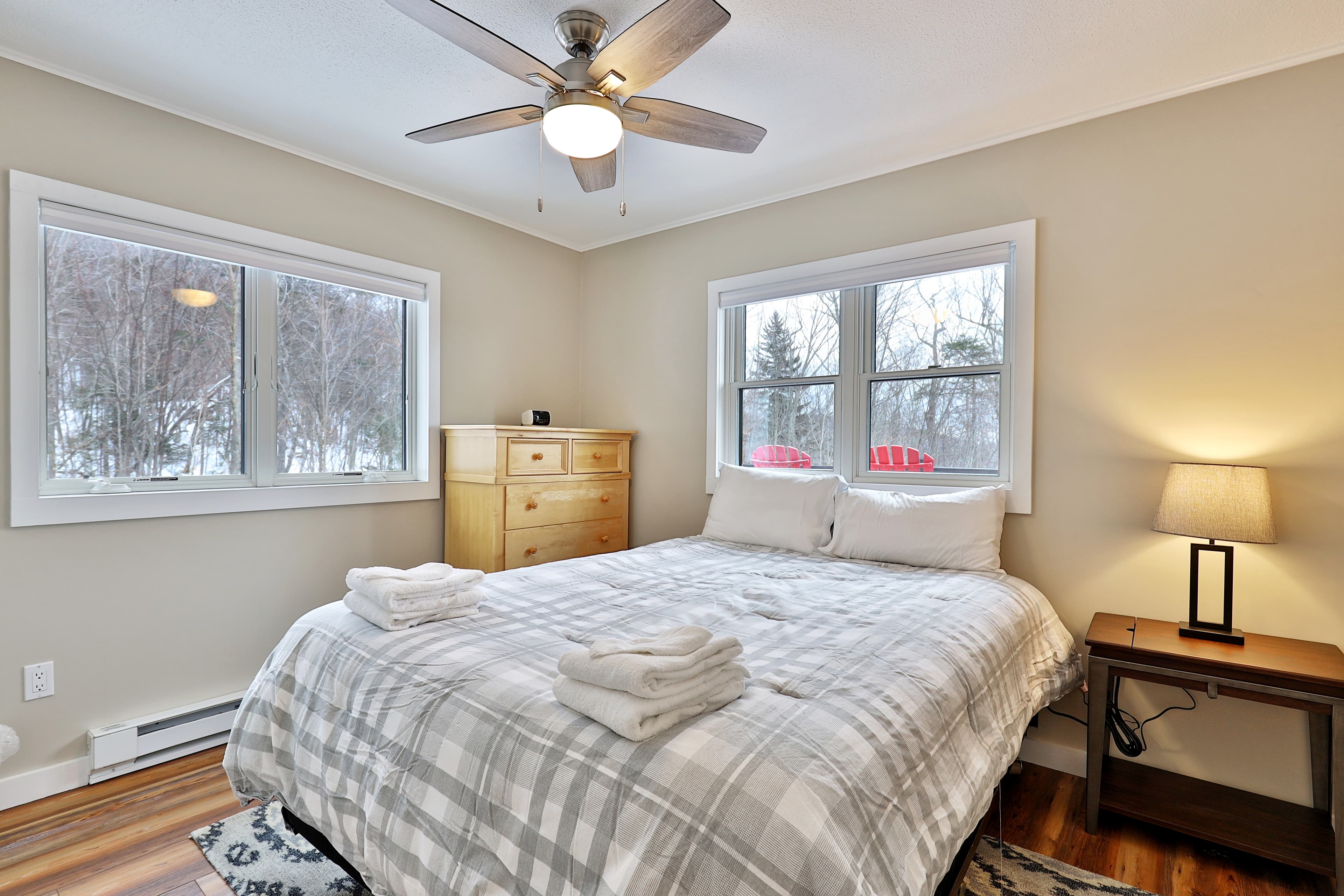 Bedroom with a queen bed and lots of wooded views.