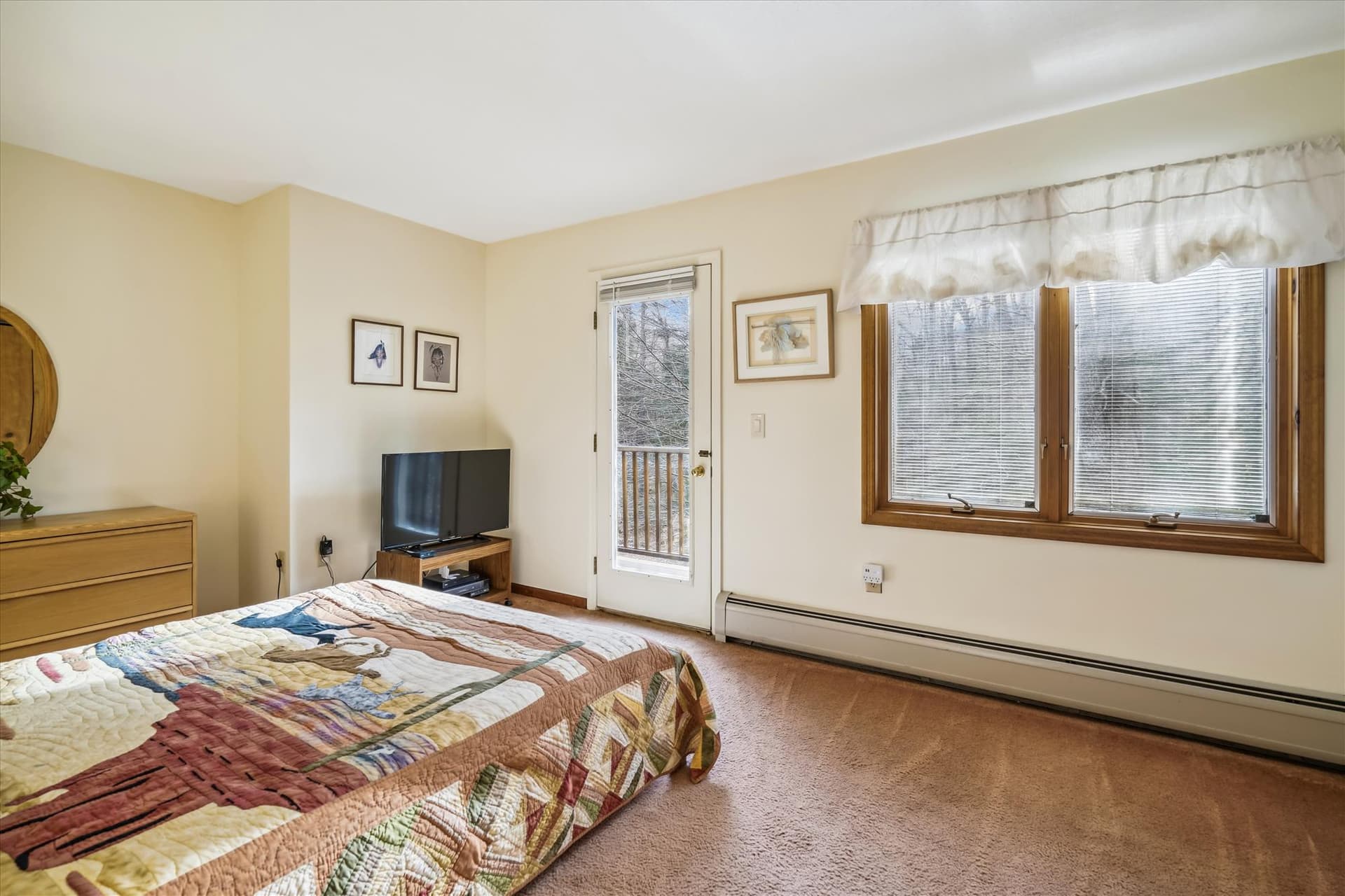A well lit bedroom. Go out on the small balcony.
