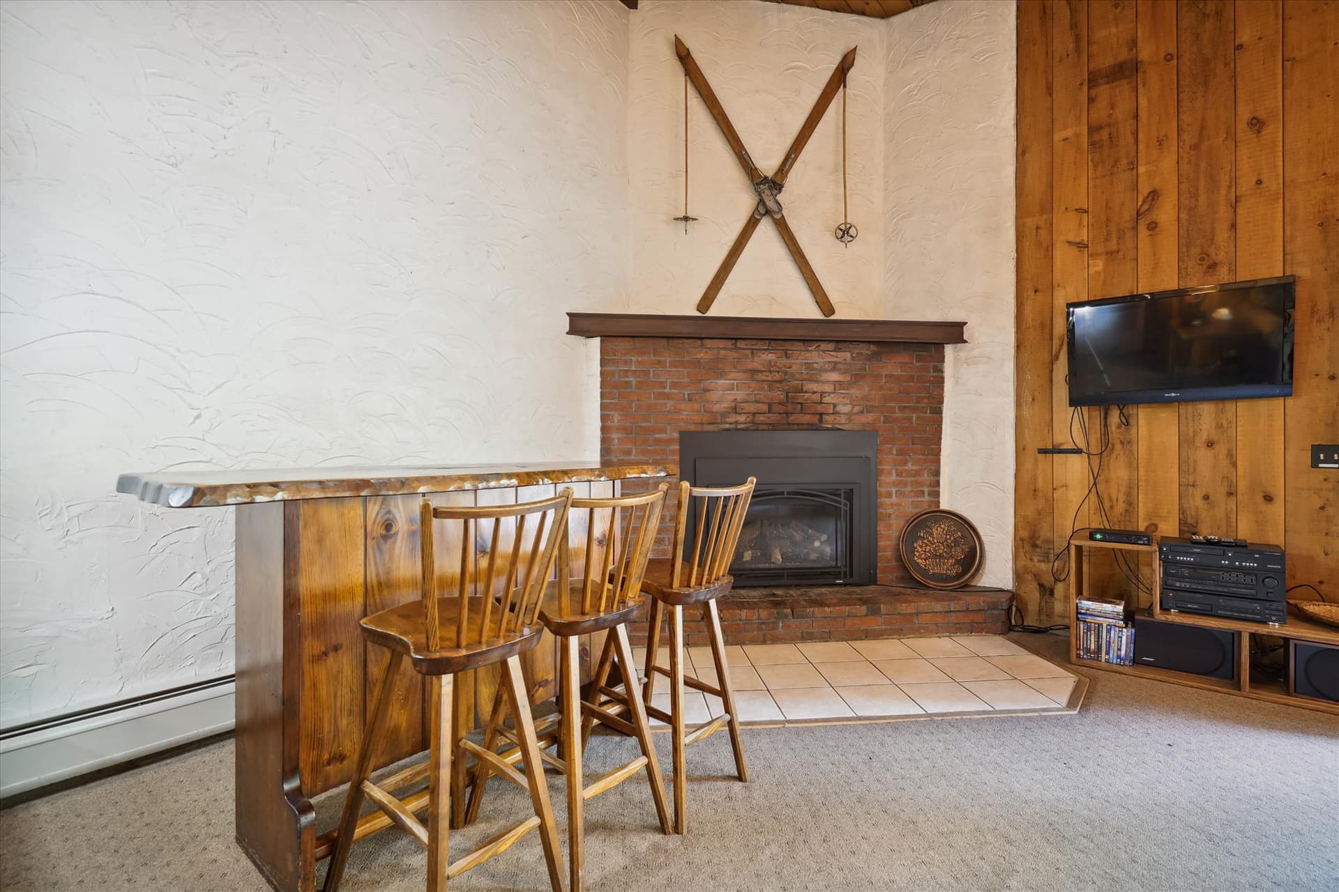 Propane fireplace and seating at small bar and a flat screen tv for your entertainment.