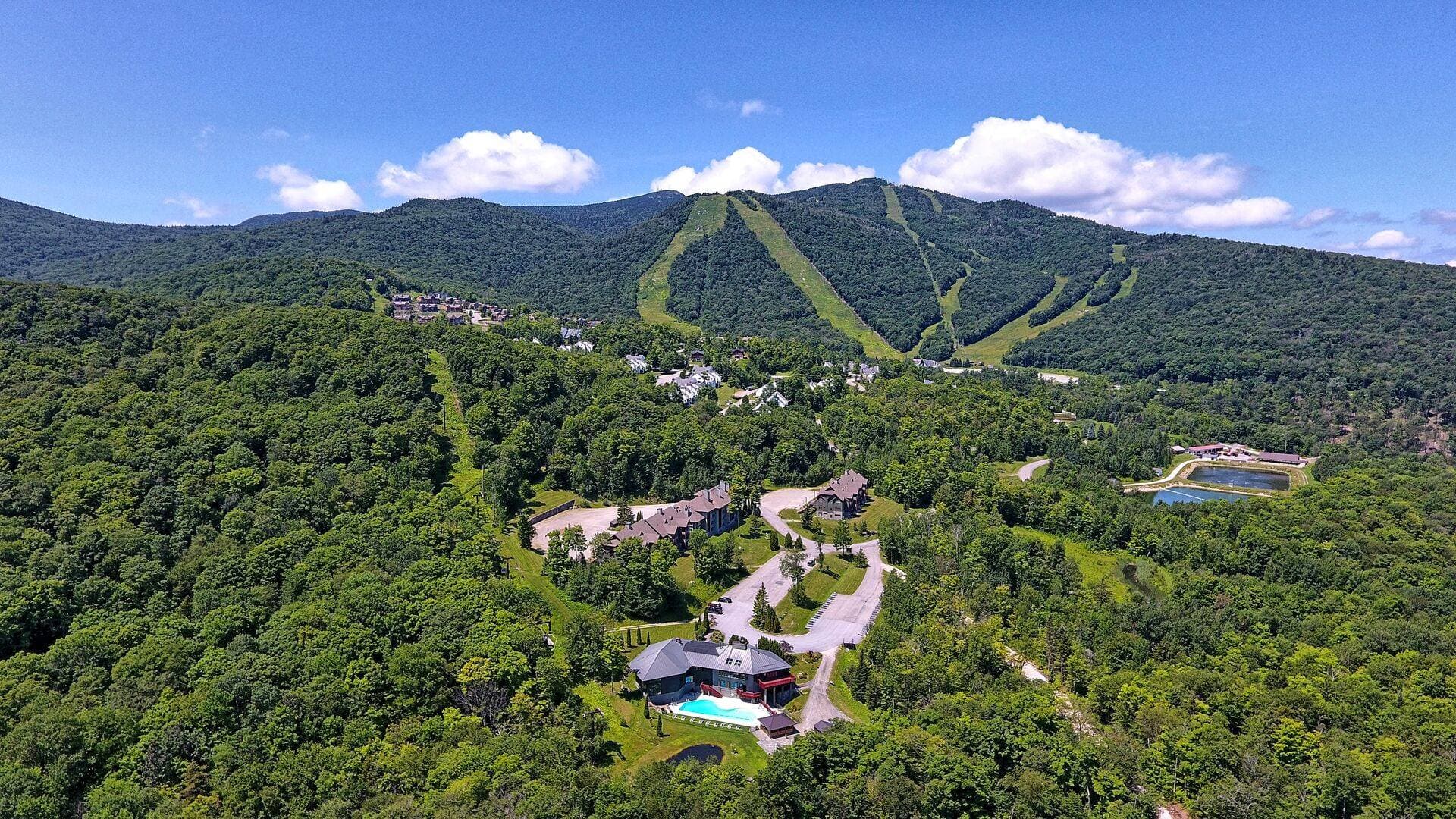 Stunning summertime views of The Lodges nestled among the mountains. Enjoy the outdoor pool, nearby hiking trails, and peaceful Vermont landscapes.