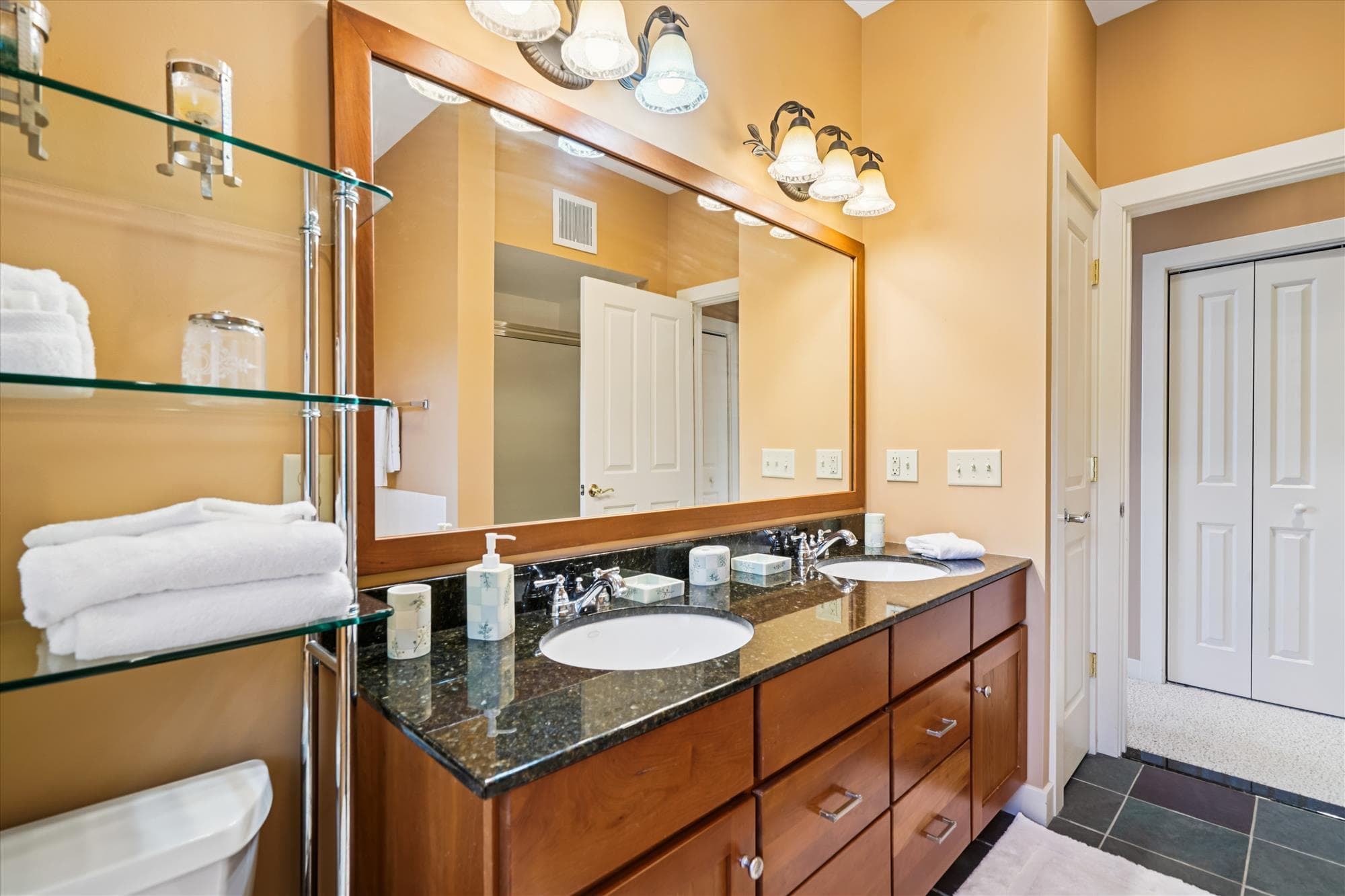 Private ensuite with double vanity, walk-in shower, and whirlpool tub overlooking Vermont's landscape. A bright, well-designed space to refresh and unwind after the day.