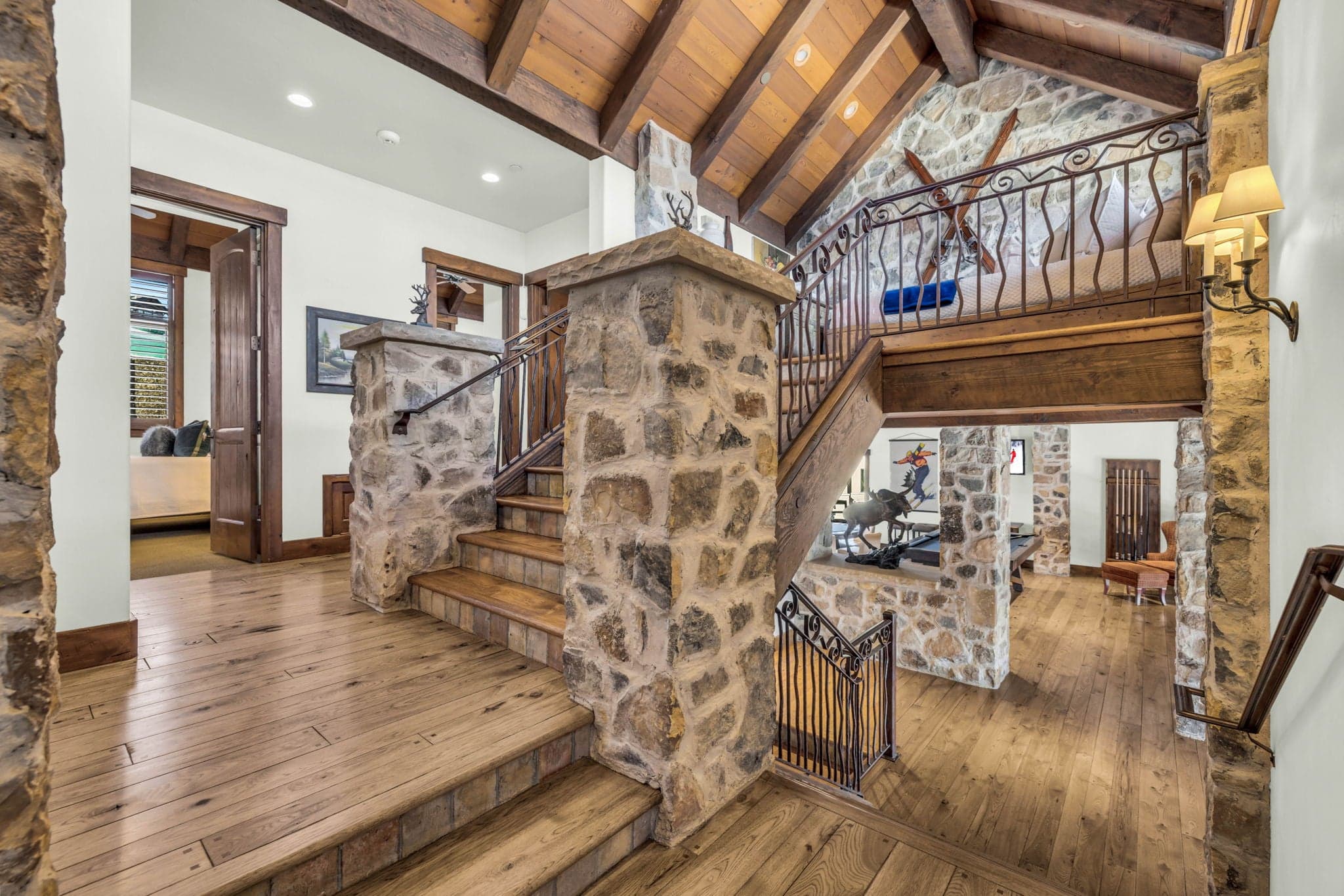 Entryway with stone staircase leading to upper and lower levels in a luxury mountain home.
