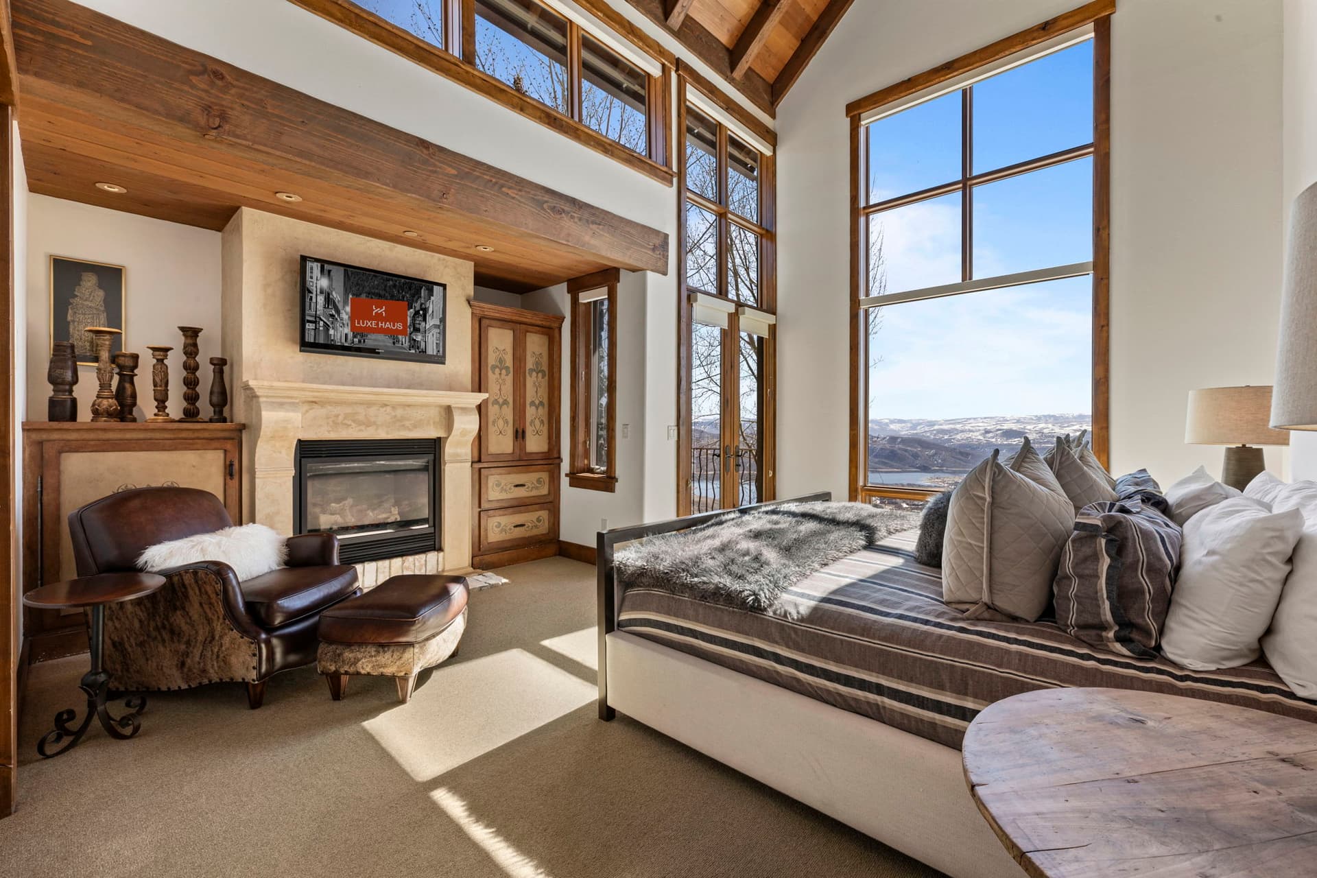 Primary suite with fireplace, vaulted ceilings, and private seating area.