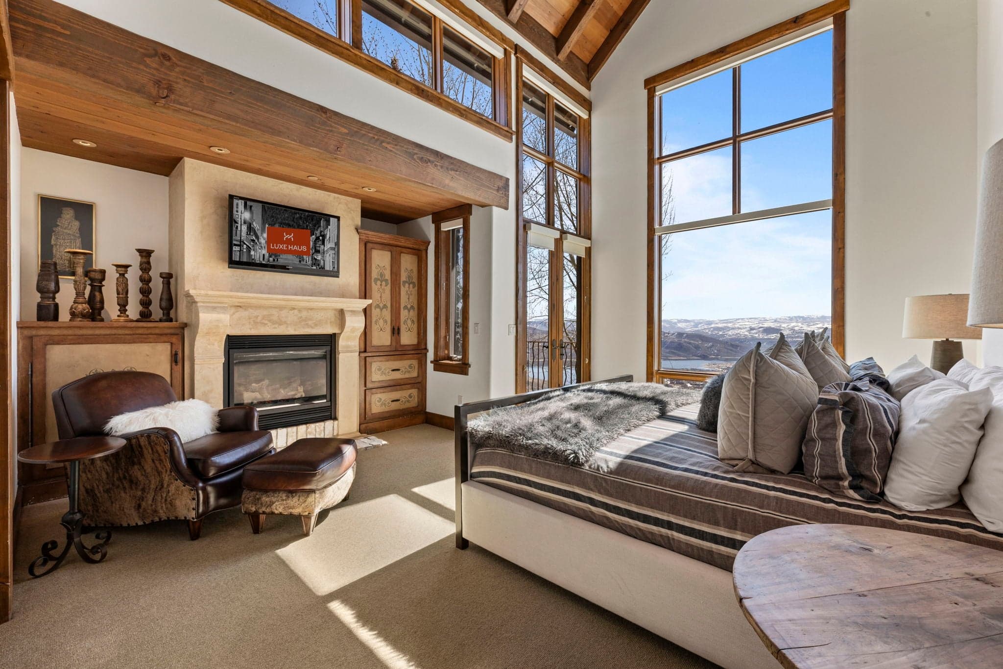 Primary suite with fireplace, vaulted ceilings, and private seating area.