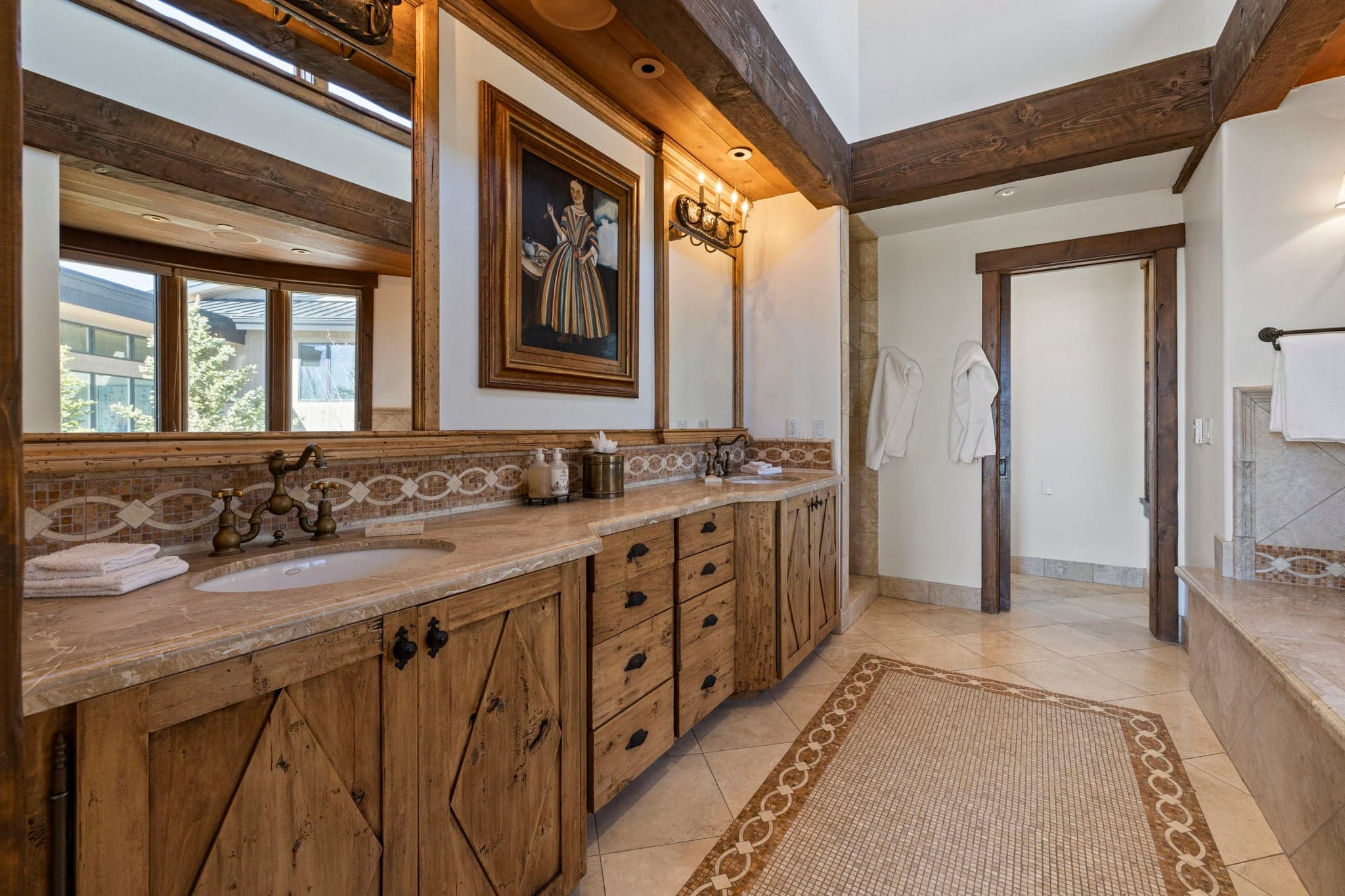 Luxury bathroom vanity with dual sinks, stone counters, and wood cabinetry.