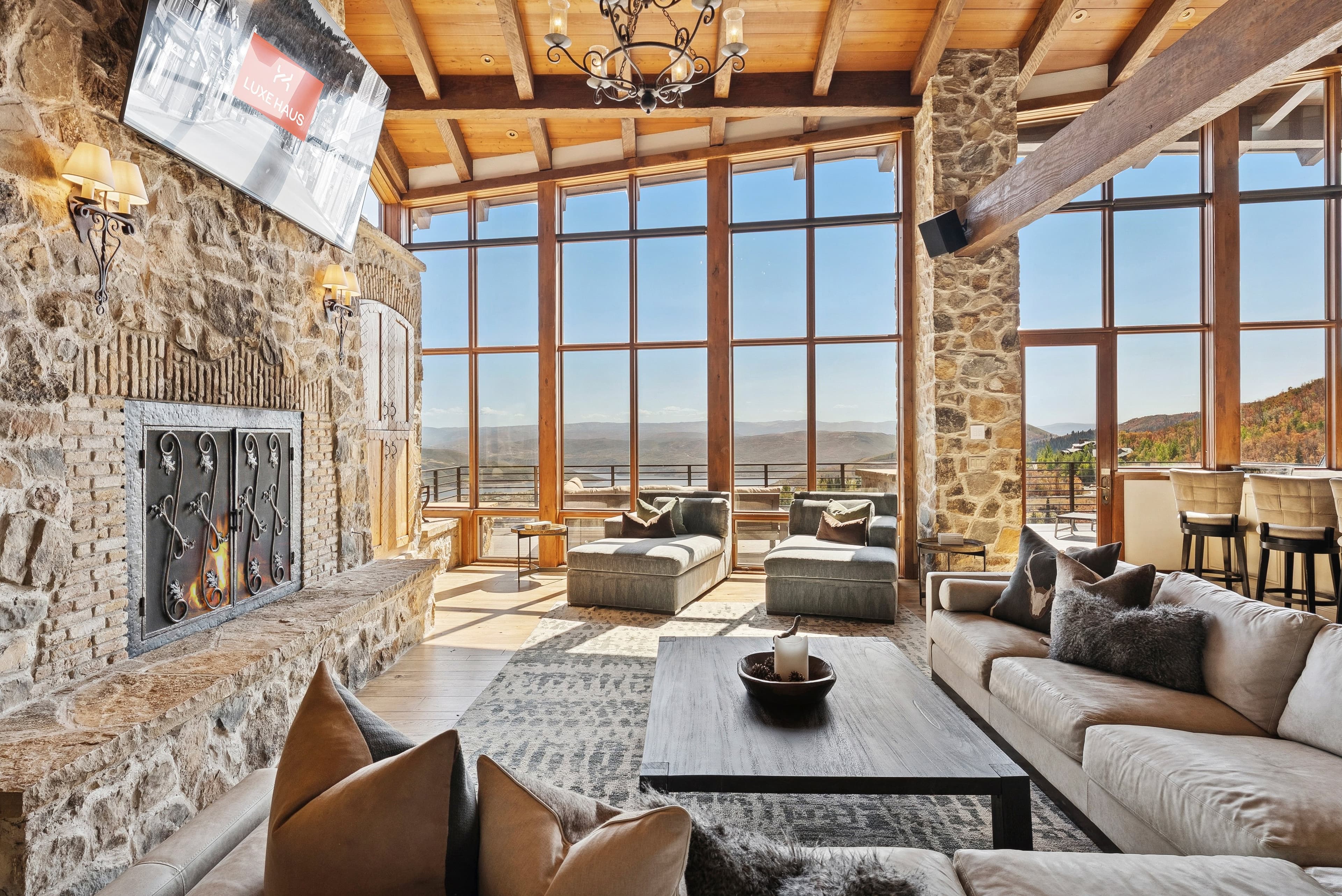 Elegant mountain living room with tall stone fireplace and panoramic views.