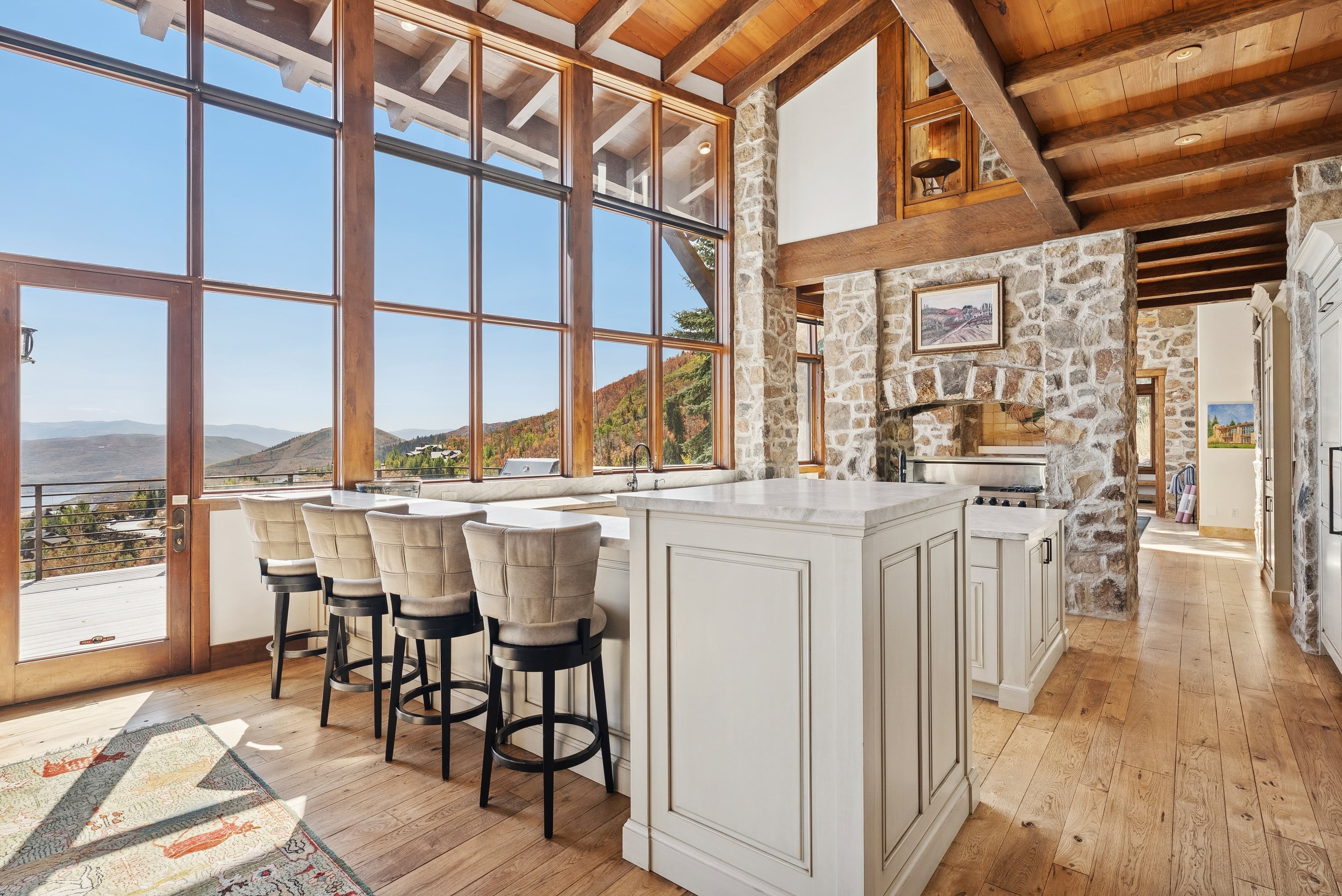 Gourmet kitchen with marble island, bar seating, and large windows overlooking the mountains.