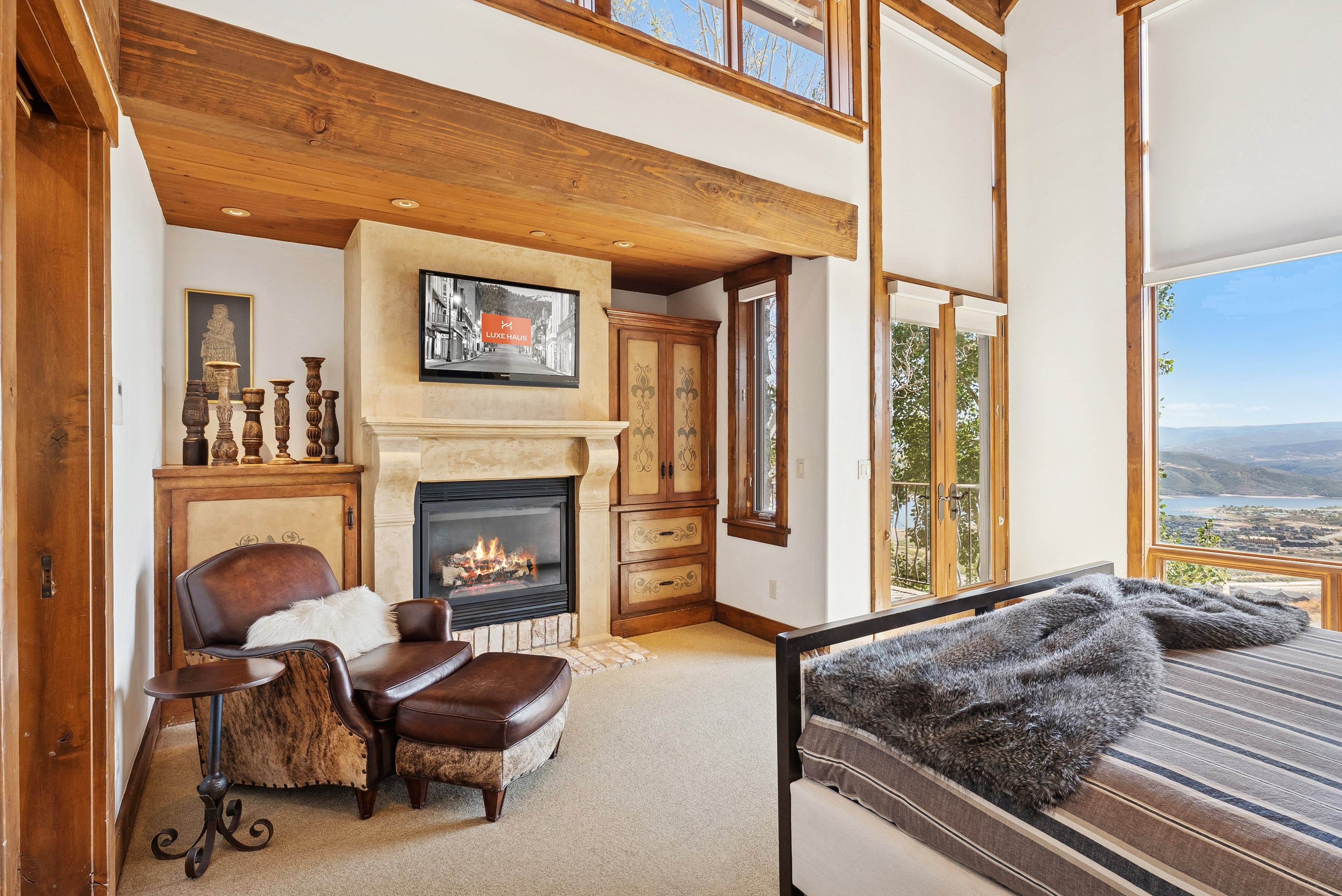Bedroom fireplace with stone surround, wood accents, and cozy seating.
