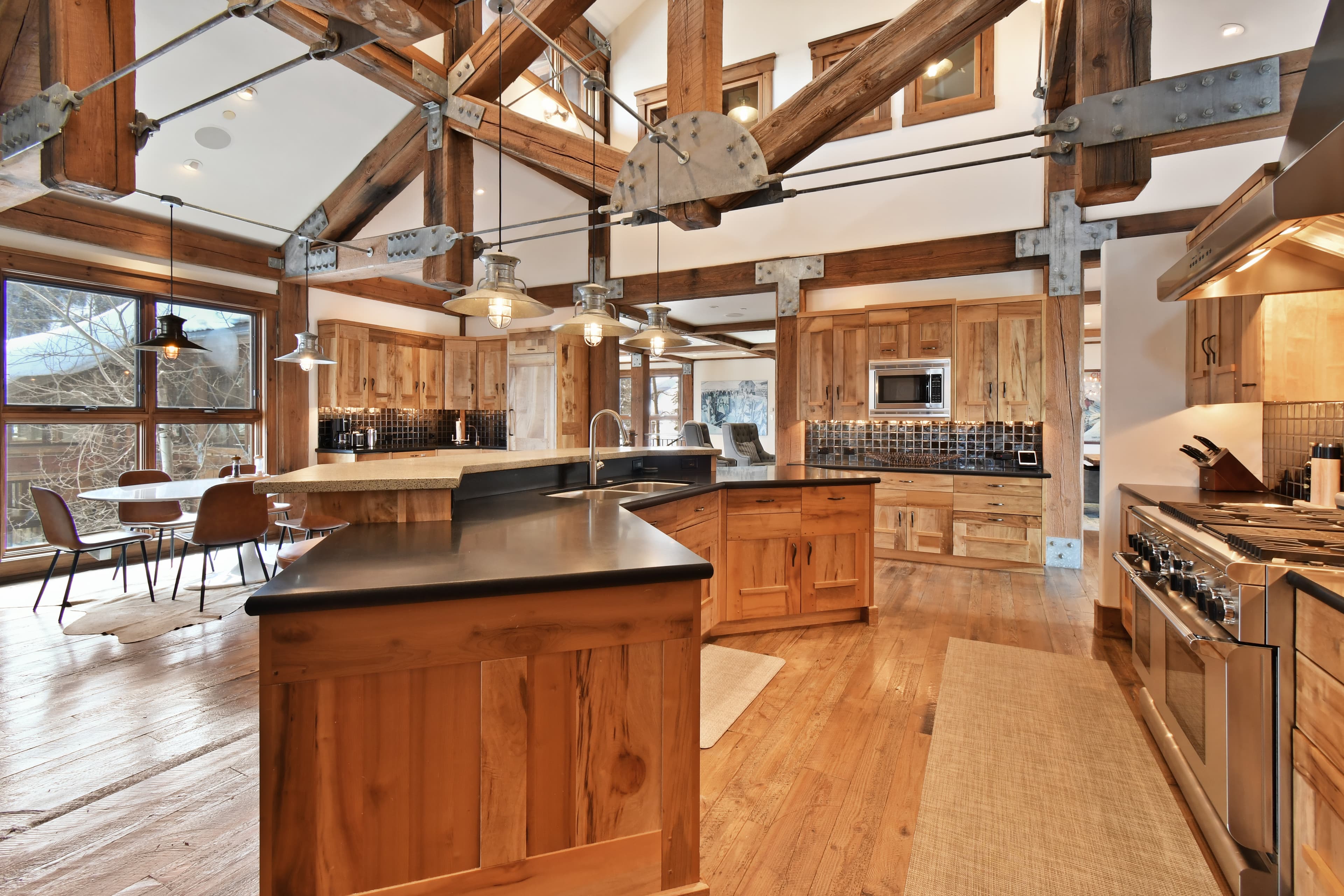 A large kitchen island sits in the middle of the kitchen, with the dining table, microwave, and oven visible.