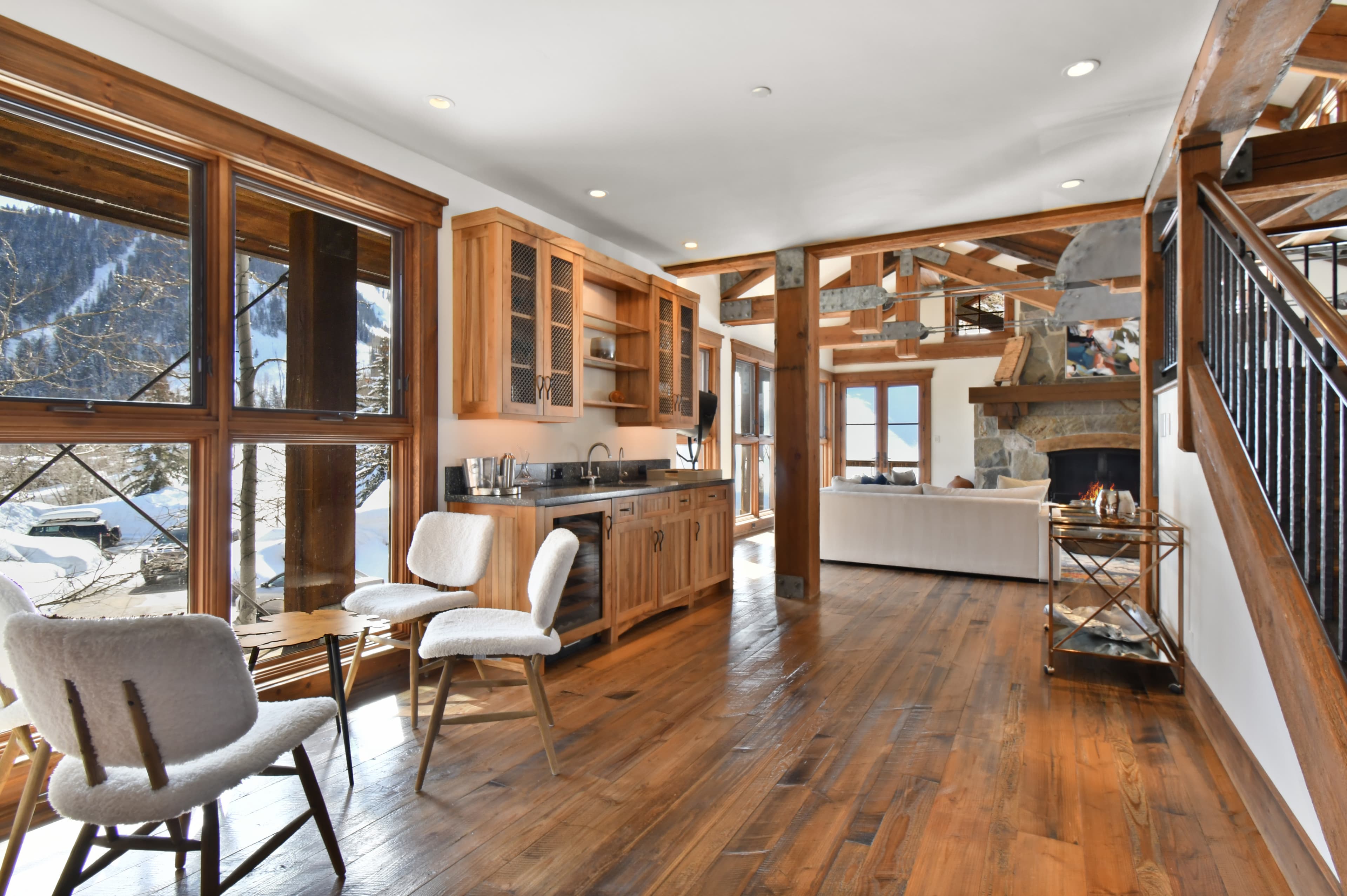 A wet bar alcove by floor to ceiling windows, with a small table and chairs in front of the view.