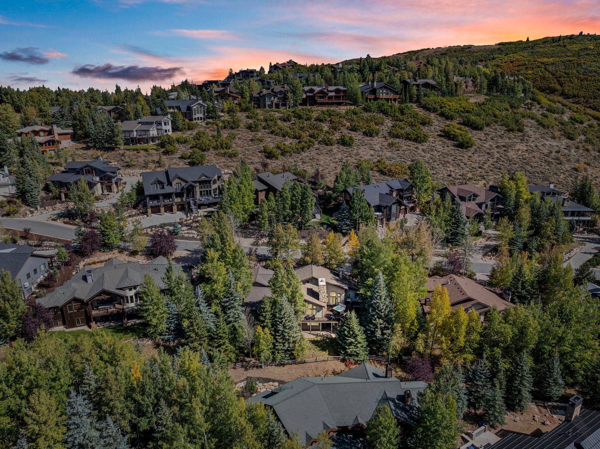 Aerial View of Home Area with Surrounding Houses and Wooded Landscapes.