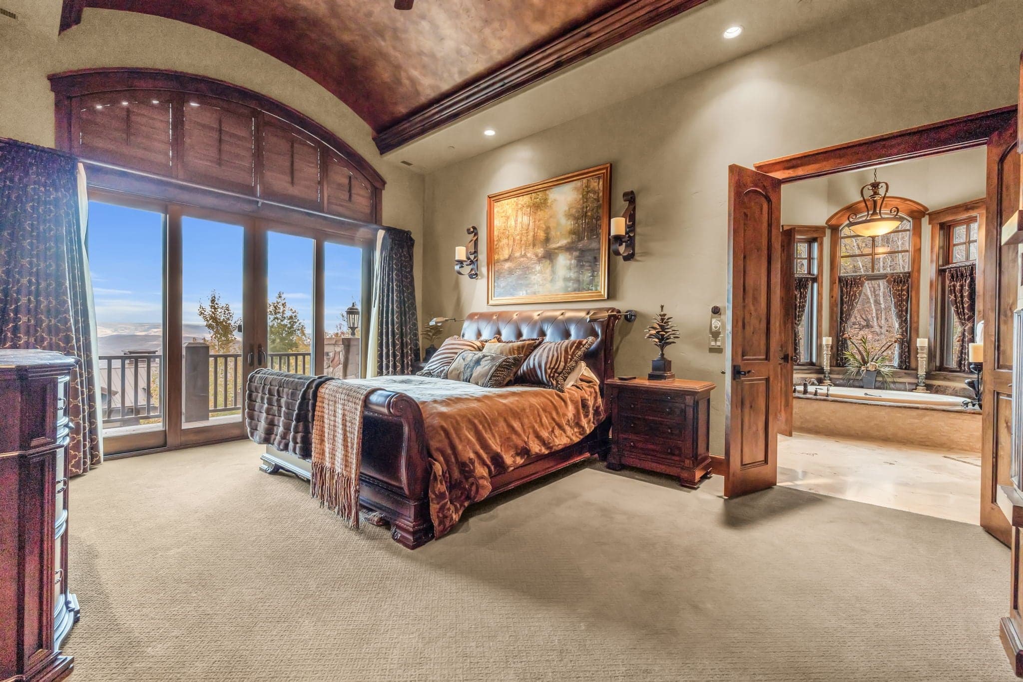 Mountain and hot tub view from Morning Star bedroom, featuring leather headboard.