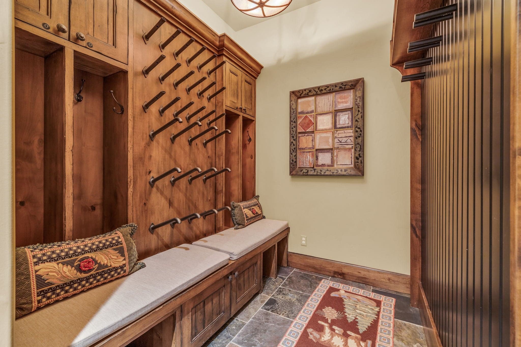Wooden mud room adorned by storage for hanging shoes and coats .