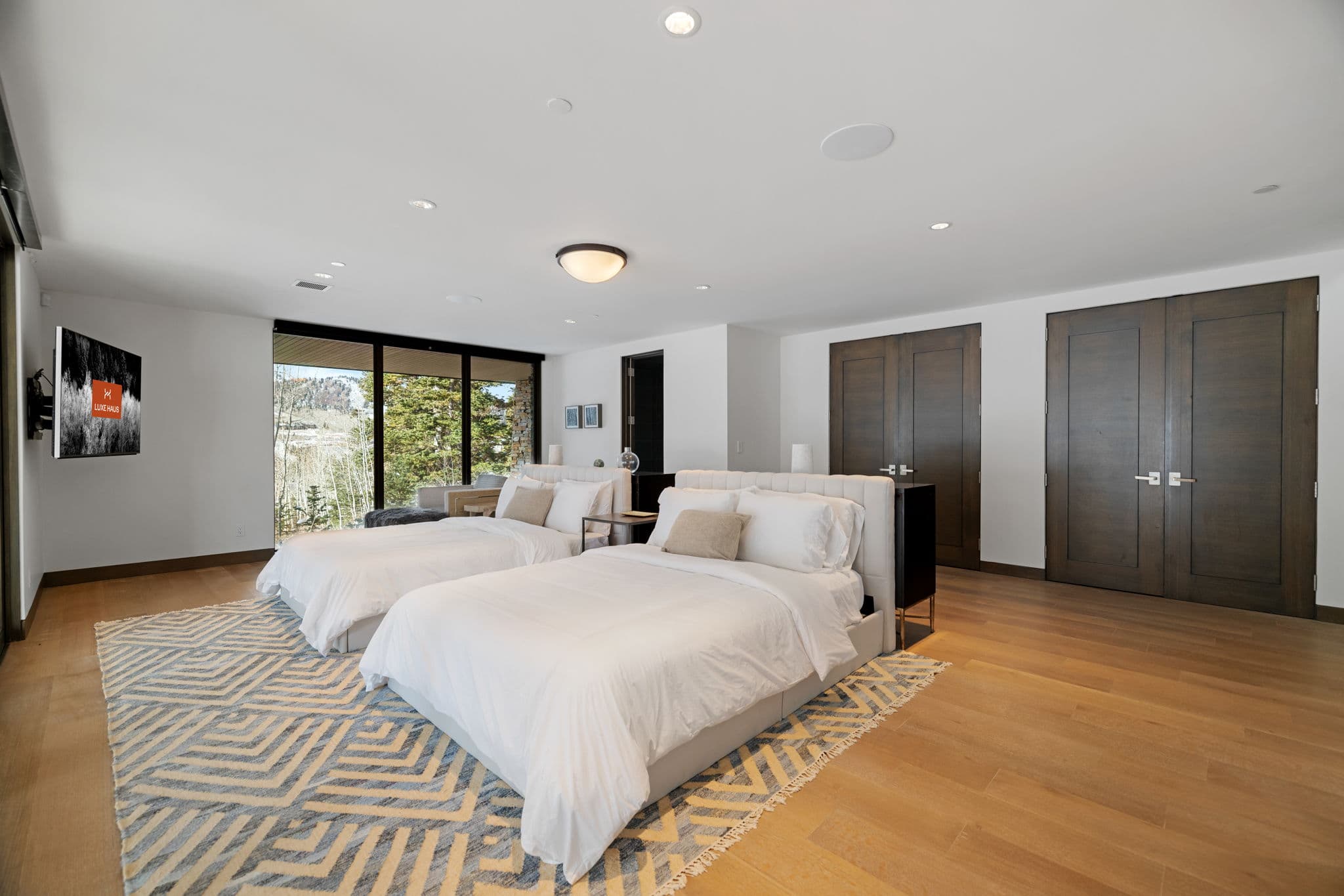 A bedroom with two beds and a flatscreen tv.