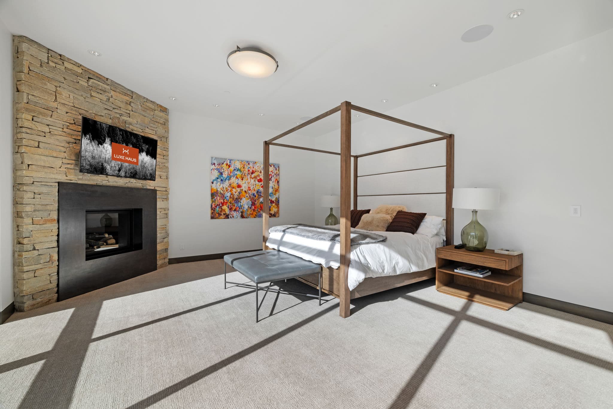 A bedroom with a fireplace and a four-post bed.