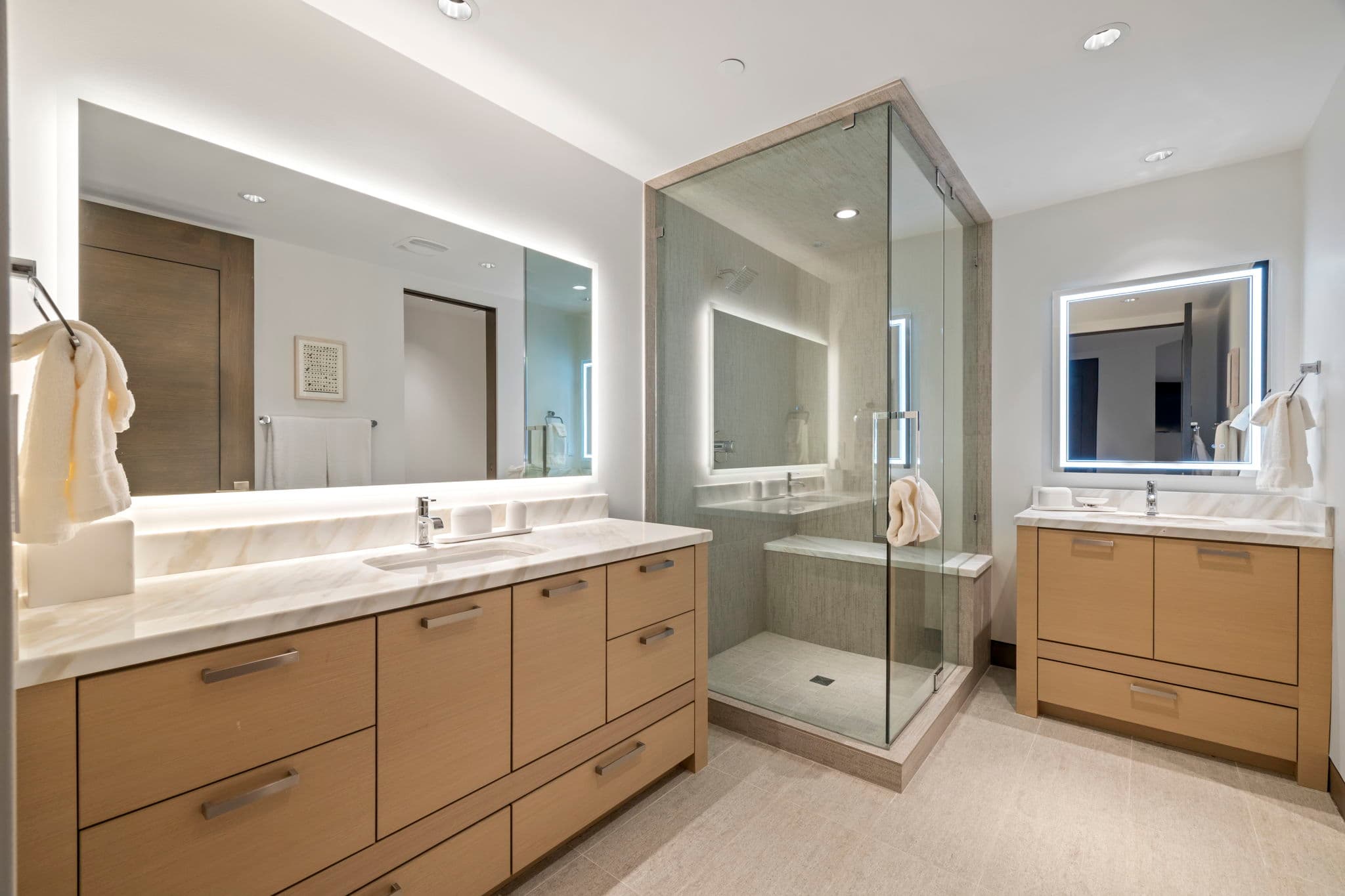 A large bathroom with a shower and two sinks.