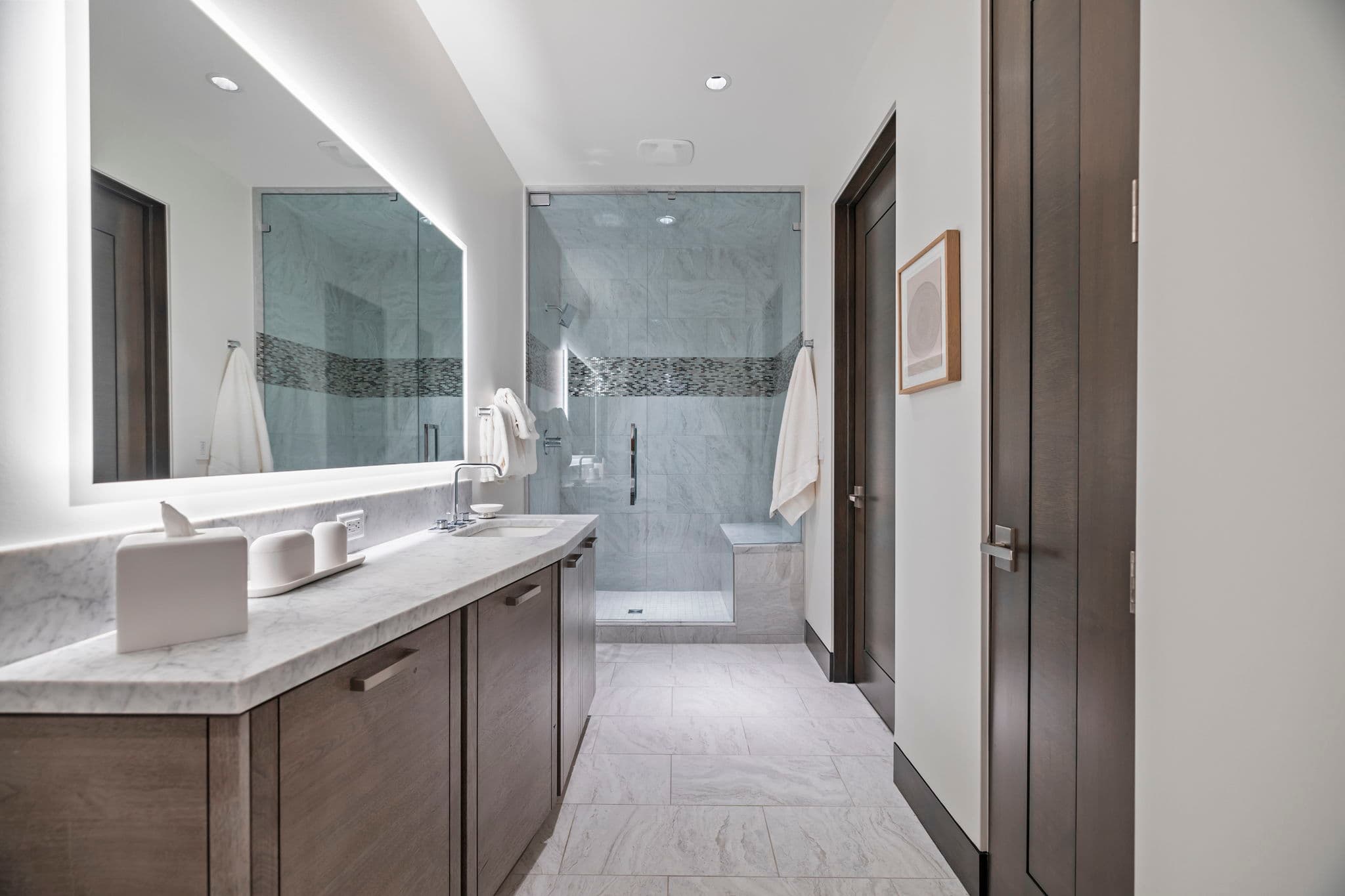 A modern bathroom with a single sink and a shower.