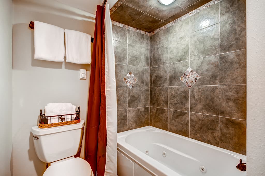 Jetted tub and shower combo in shared lower level bathroom - 4 O'Clock Lodge D26 Breckenridge Vacation Rental