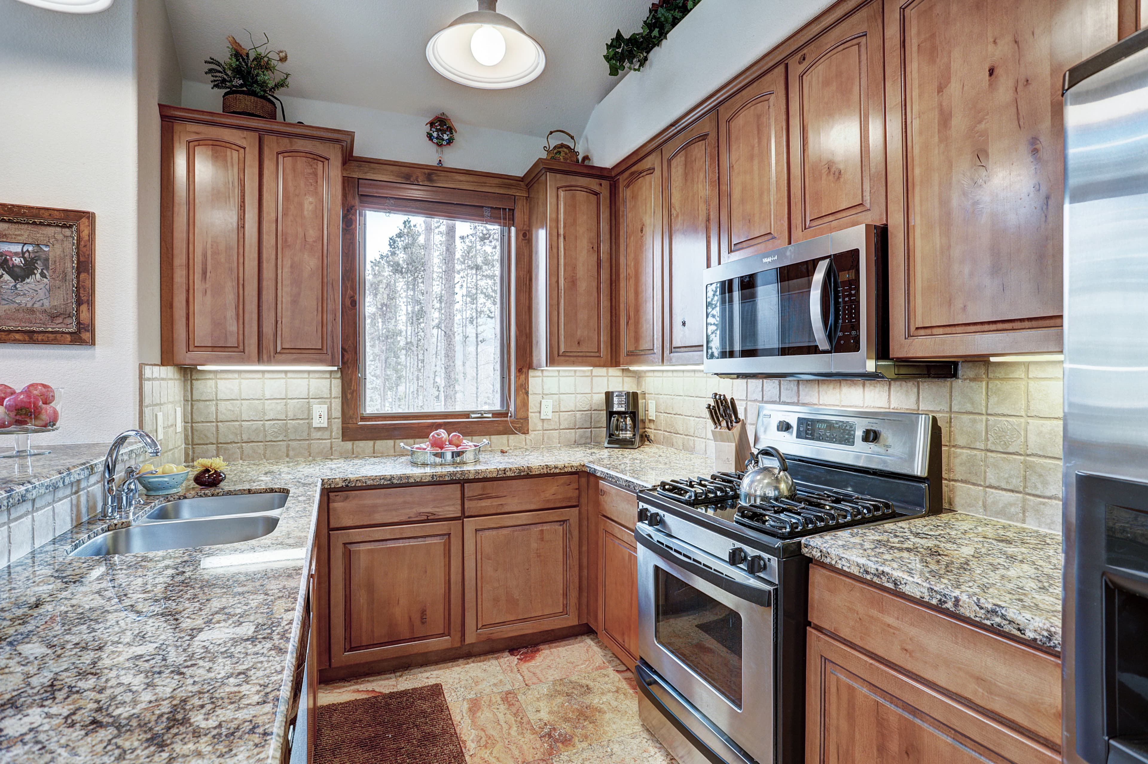 This spacious kitchen boasts updated stainless steel appliances and granite countertops - Amber Sky Breckenridge Vacation Rental