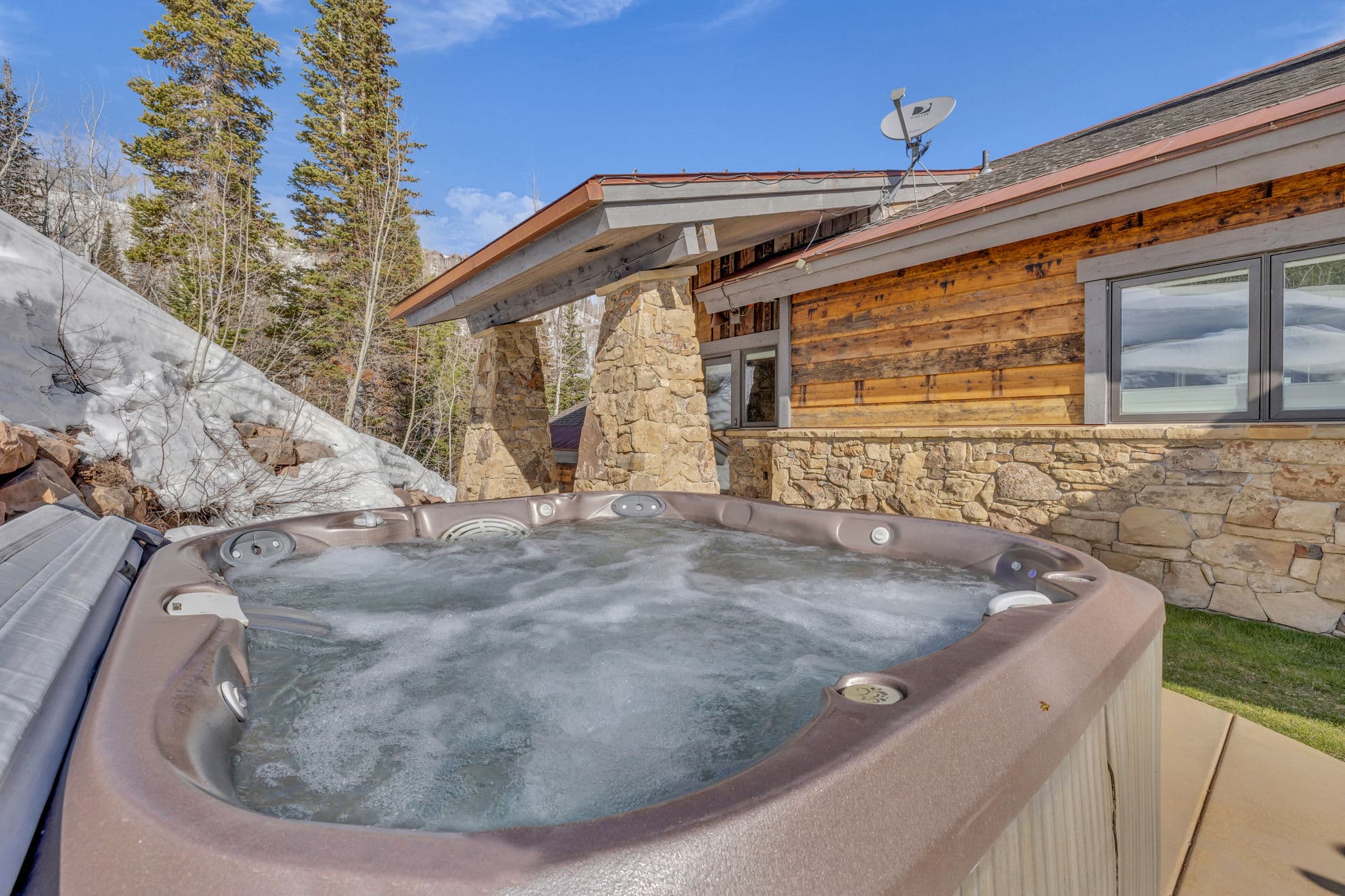 view of hot tub with home in the background