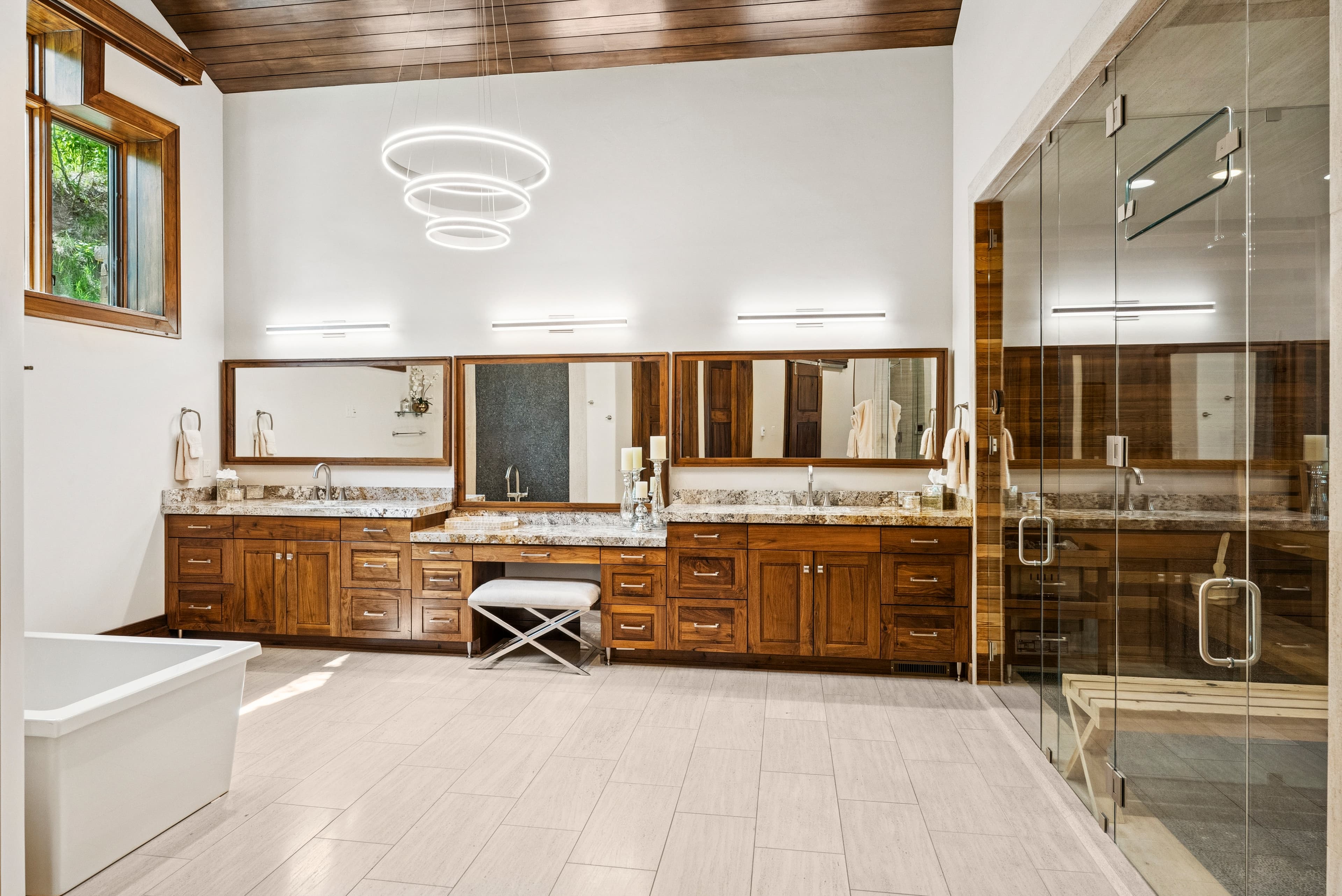 massive primary bathroom with double sink vanity, makeup counter and large walk in shower