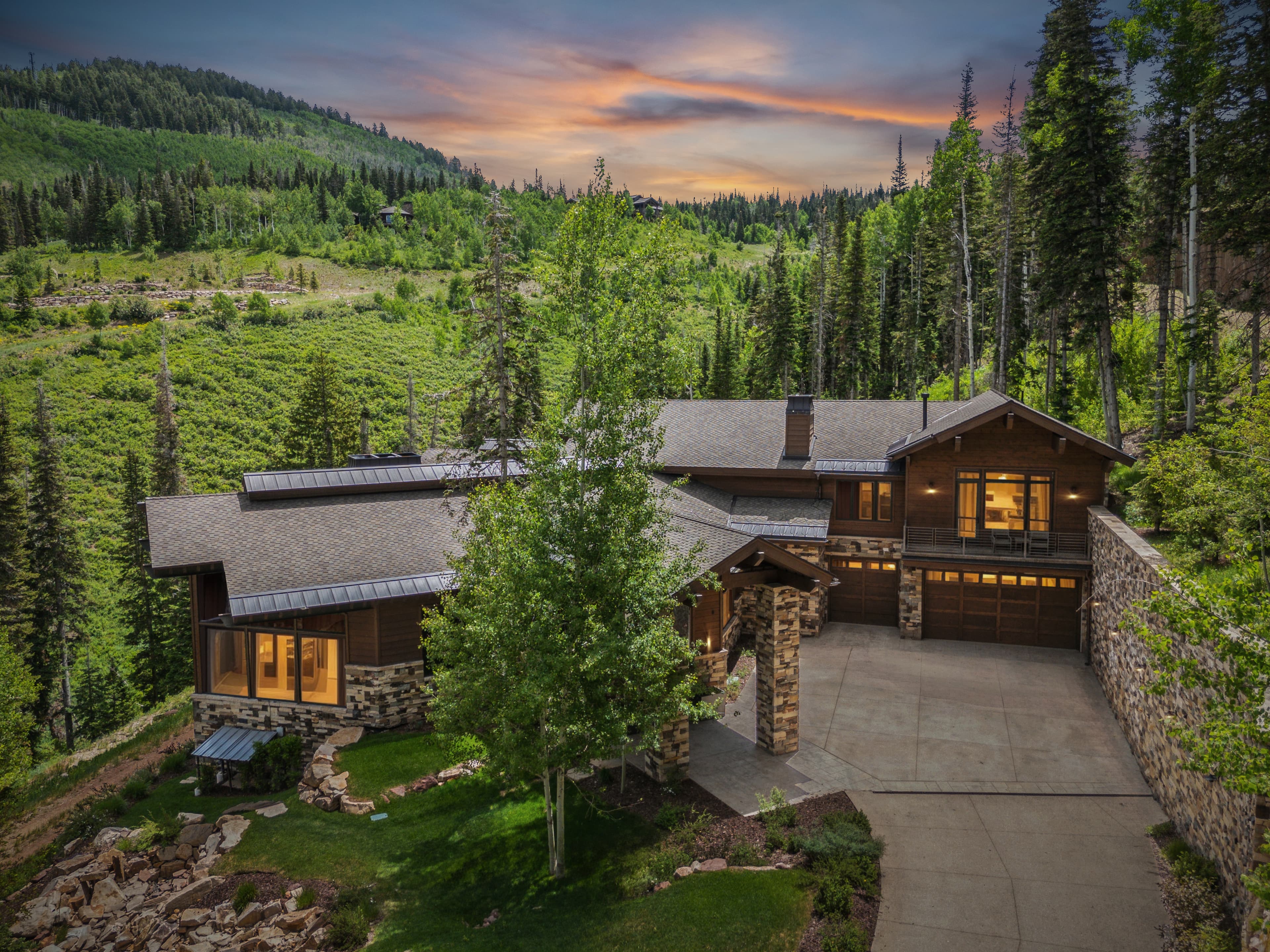 a view of the driveway and the back of the home at grandview in park city with the mountains in the background