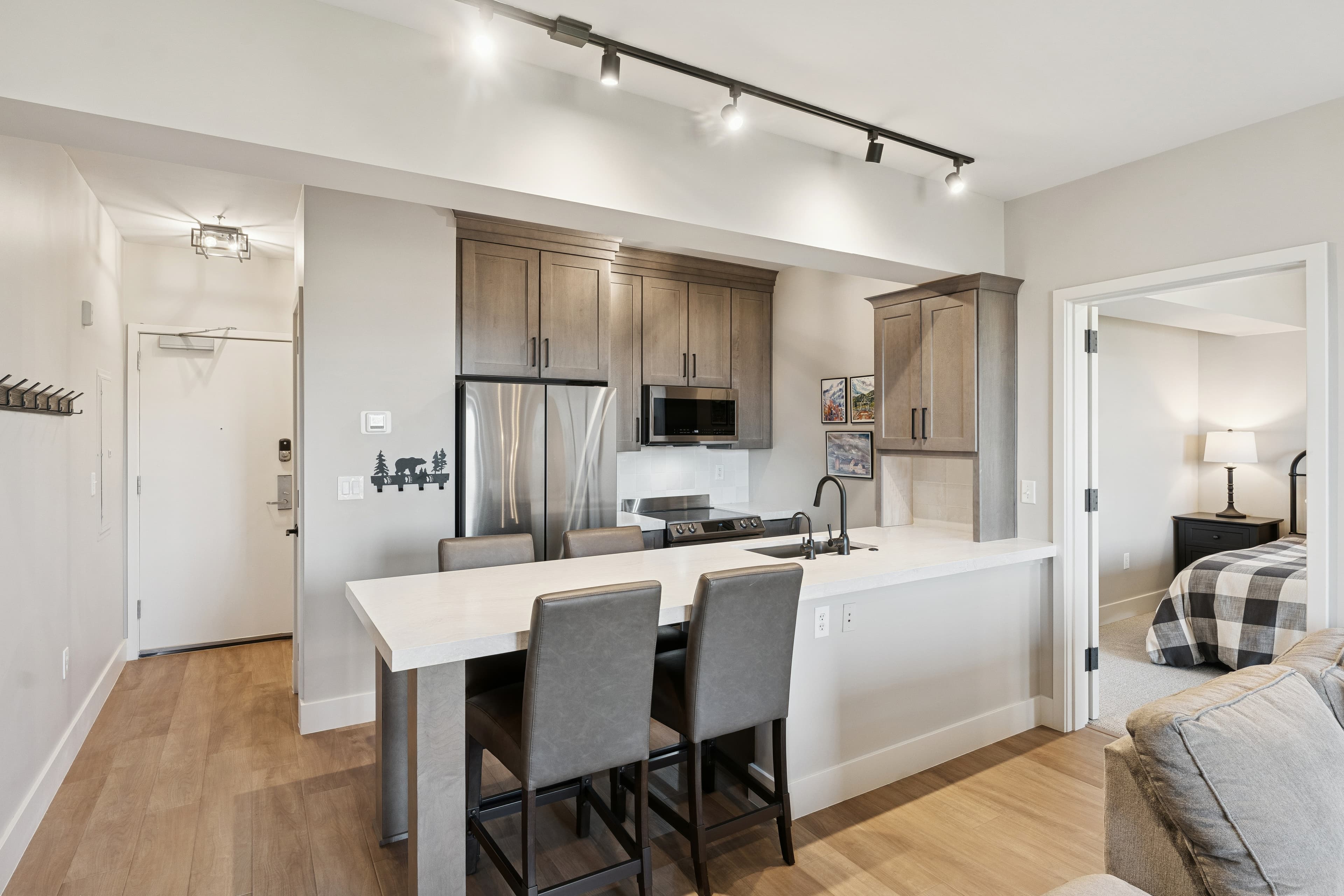 Open-concept kitchen and dining area in a Park City condo, featuring wood finishes and upscale appliances.